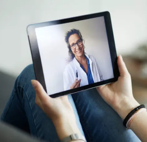 Woman holding tablet while having a video call with a female doctor Woman holding tablet while having a video call with a female doctor