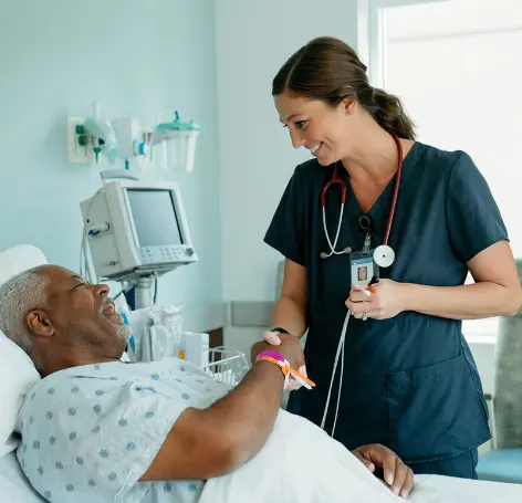 Female medical doctor talking with senior African-American man in a hospital room Female medical doctor talking with senior African-American man in a hospital room