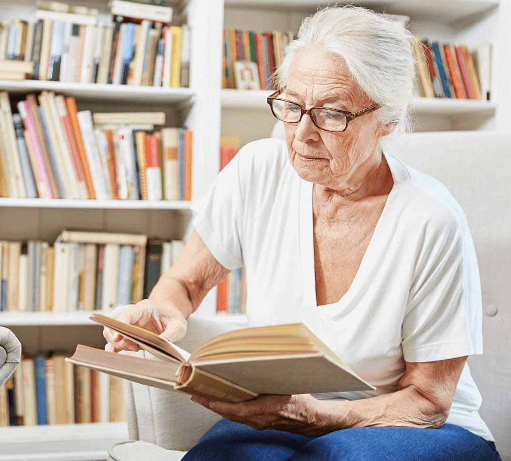 Senior woman reading a book with new eyeglasses