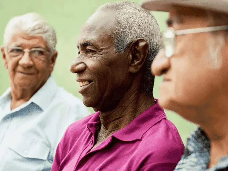Three senior men talking and smiling