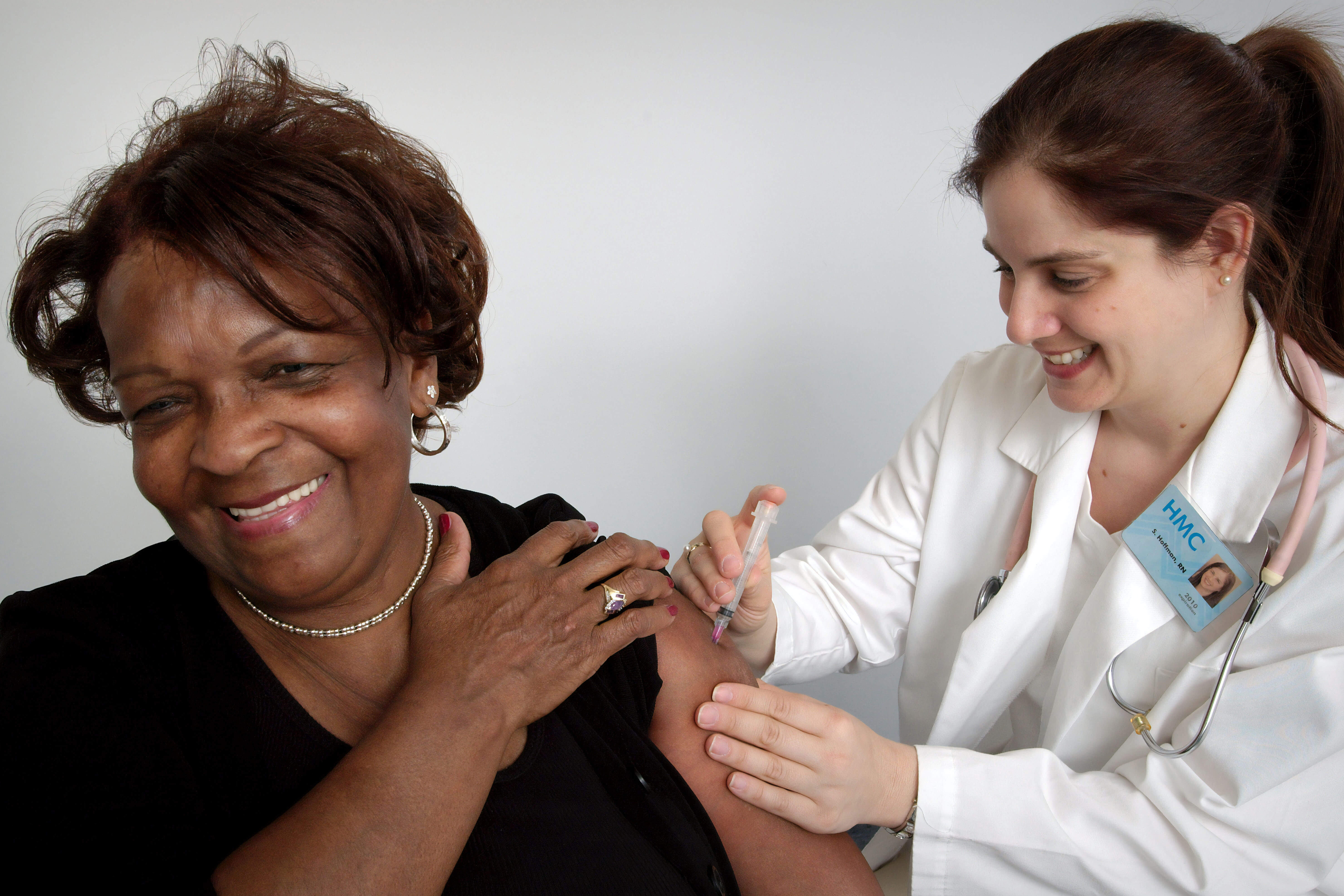 African-American woman receiving a shot from a female doctor