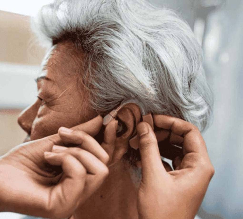 Senior African-American woman getting a hearing aid fitted